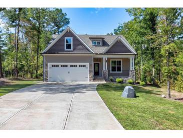 Attractive exterior view of a craftsman-style home with a two-car garage and stone detailing at 3627 River Watch Ln, Franklinton, NC 27525