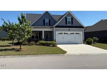 Charming two-story home with a manicured lawn, attached garage, and craftsman details at 47 Scarlet Bell Dr, Youngsville, NC 27596
