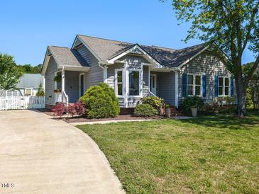 Charming gray home with a well-manicured lawn, inviting curb appeal, and a concrete driveway at 4908 Birkenhead Ct, Apex, NC 27539