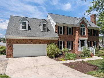 Charming two-story brick home with a two car garage, dormers, and professional landscaping at 5 Bobby Parker Pl, Durham, NC 27703