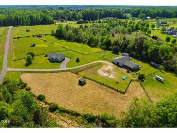 Expansive aerial view of property featuring the home, barn, pastures and lush green acreage at 5916&5918 Laws Farm Rd, Rougemont, NC 27572