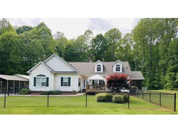 Charming home with white siding, green shutters, and a fenced yard at 67 Bull Run N, Timberlake, NC 27583