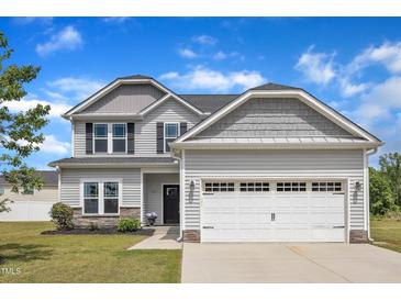 Charming two-story home with a two-car garage, light gray siding, and a well-manicured lawn at 1013 Fieldmere Pl, Wendell, NC 27591