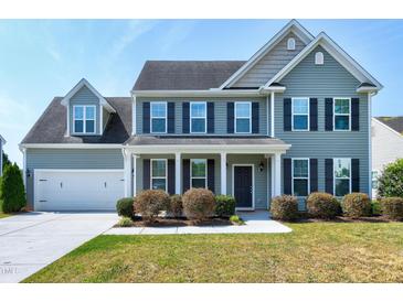 Charming two-story home featuring well-maintained landscaping, a covered porch, and an attached two-car garage at 120 Shore Pine Dr, Youngsville, NC 27596