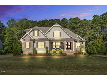 Charming two-story home featuring stone accents, a covered front porch and mature trees at 128 Paraggi Ct, Clayton, NC 27527