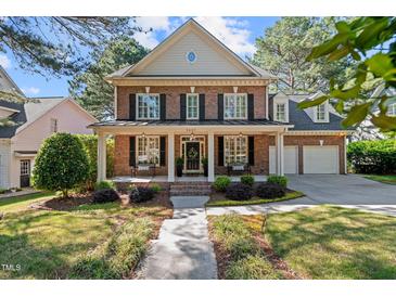 Charming brick home with a welcoming front porch, black shutters, and manicured landscaping at 1401 Marshall Farm St, Wake Forest, NC 27587
