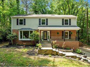 Charming two-story home with brick facade, bay window, covered porch, and beautiful stone stairs at 1509 Cumberland Rd, Chapel Hill, NC 27514