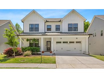 Charming two-story home featuring a classic white facade, black-framed windows, and an attached two-car garage at 1709 Chestnut Falls Rd, Wendell, NC 27591