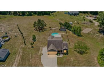 Expansive lot with pool, outbuilding, and charming home with mature trees and lawn at 187 Old Johnson Rd, Wendell, NC 27591