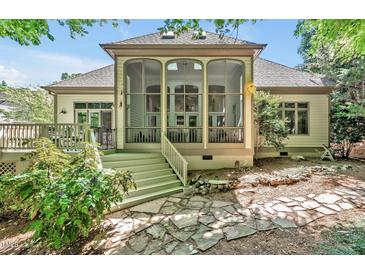 Inviting screened porch features a stone tile path and a charming connection to a backyard deck at 20011 Bragg, Chapel Hill, NC 27517