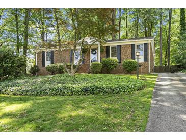 Charming brick home features a manicured front yard and lush landscaping at 215 Westridge Dr, Raleigh, NC 27609