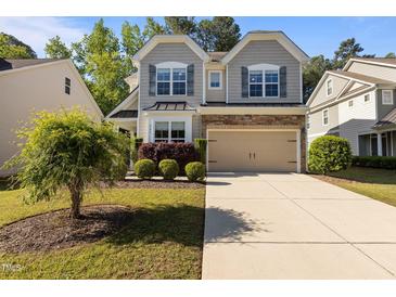 Charming two-story home with a manicured lawn and two-car garage at 221 Hammond Wood Pl, Morrisville, NC 27560
