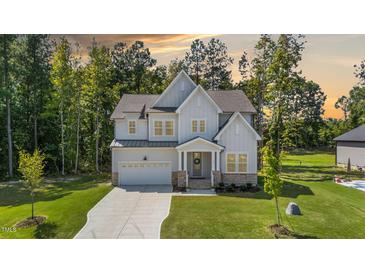 Charming two-story home with stone accents, a manicured lawn, and an attached two-car garage at 300 Scotland Dr, Youngsville, NC 27596