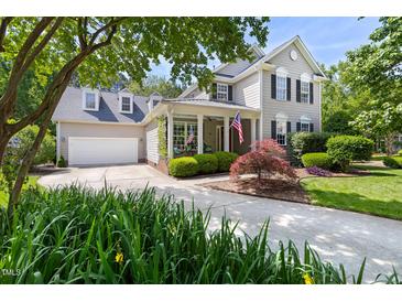 Charming two-story home featuring a well-manicured lawn, a driveway, and a covered porch adorned with American flags at 30150 Walser, Chapel Hill, NC 27517