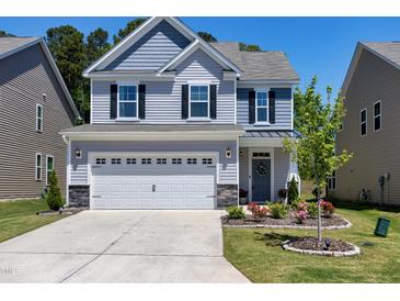 Charming two-story home featuring a two-car garage, gray siding, and a well-manicured front lawn at 3017 Ginger Hill Ln, Durham, NC 27703