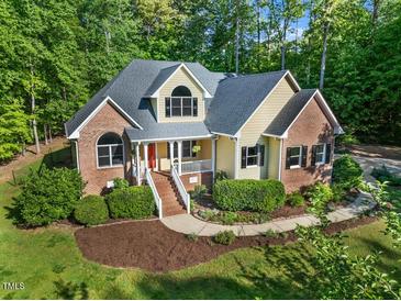 Charming two-story home with brick and siding, a well-manicured lawn, and mature trees at 3035 Tavistock Dr, Durham, NC 27712