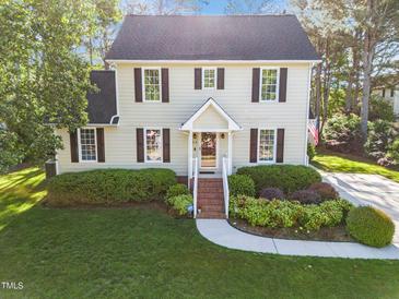 Charming two-story home with a well-manicured lawn and lush landscaping enhancing its curb appeal at 3204 Terrel Mill Rd, Raleigh, NC 27616