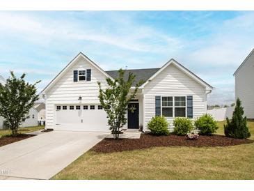 Charming single-story home with white siding, a two-car garage, and well-manicured landscaping at 321 Everly Mist Way, Wake Forest, NC 27587