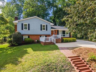 Charming two-story home with a manicured lawn, brick accents, and inviting front porch at 3425 Brentwood Rd, Raleigh, NC 27604