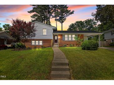 Charming home featuring a brick and vinyl exterior with a walkway and lush green lawn at 3501 Arrowwood Dr, Raleigh, NC 27604