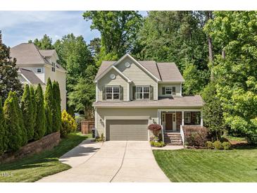 Charming two-story home featuring a manicured lawn, attached two-car garage, and traditional design elements at 3612 Carriage Dr, Raleigh, NC 27612