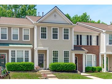 Charming townhouse with light siding, complemented by lush green bushes and a well-manicured lawn at 4535 Sugarbend Way, Raleigh, NC 27606