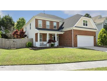 Charming two-story home with a partial brick facade, well-manicured lawn, and inviting front porch at 5213 Holly Ridge Farm Rd, Raleigh, NC 27616