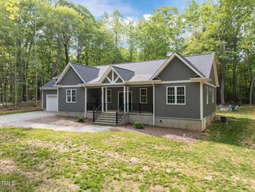Charming exterior of a gray home featuring a covered porch, white trim, and a well-maintained front yard at 5402 Shealtiel Way, Rougemont, NC 27572