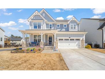 Charming two-story home with a welcoming front porch, beautiful stone accents, and a well-manicured lawn at 6633 Penfield St, Wake Forest, NC 27587