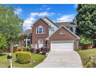 Charming two-story brick home featuring an attached two-car garage and beautifully landscaped front yard at 7 Bonham Ct, Durham, NC 27703
