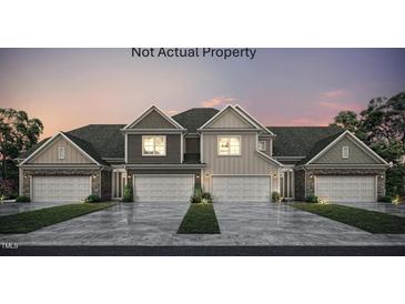 Charming duplex featuring a two-car garage, stone accents, and a well-maintained lawn at 710 Blackpool Dr, Durham, NC 27703
