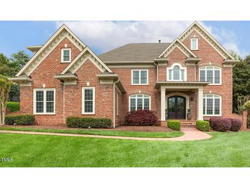 Beautiful brick home featuring a manicured lawn and an inviting, covered front entryway at 712 Evanvale Ct, Cary, NC 27518