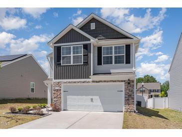 Two-story home with two-car garage, stone accents, grey siding and black shutters at 729 Little Patch St, Zebulon, NC 27597