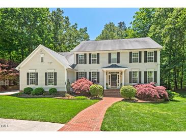 Charming two-story home with a manicured lawn, mature trees and inviting red brick walkway at 800 Oxbow Crossing Rd, Chapel Hill, NC 27516