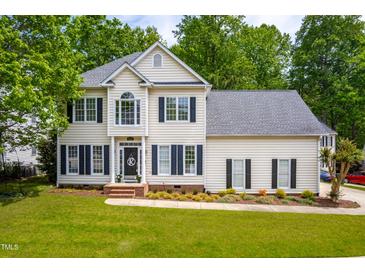 Charming two-story home with manicured lawn and mature trees, showcasing classic architectural details at 8600 Clivedon Dr, Raleigh, NC 27615