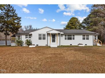 Charming single-story home featuring a white brick exterior and a well-maintained lawn at 900 Roxboro Road, Oxford, NC 27565