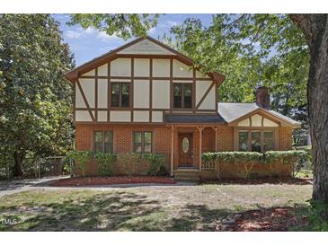 Charming Tudor-style home with brick facade, trimmed hedges, and beautiful landscaping at 101 Atchison St, Garner, NC 27529