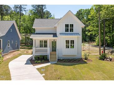 Charming two-story farmhouse with white siding, green front door, and a inviting front porch at 1013 Forrestal Pl, Durham, NC 27707