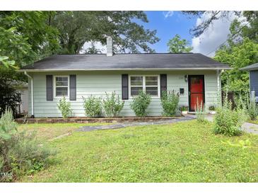 Charming home featuring light green siding, black shutters, a red front door, and lush landscaping at 106 Eugene St, Carrboro, NC 27510