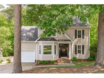 Charming two-story home featuring tan siding, dark shutters, a bay window, and a welcoming front porch at 120 Avent Pines Ln, Holly Springs, NC 27540