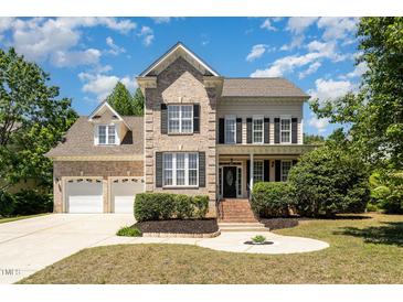 Charming brick two-story home featuring a two-car garage and inviting front yard at 1221 Tartarian Trl, Apex, NC 27502