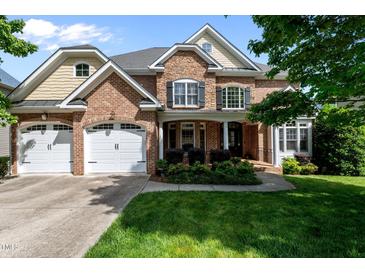 Charming brick home with a three-car garage and well-maintained landscaping in a suburban neighborhood at 12508 Angel Falls Rd, Raleigh, NC 27614