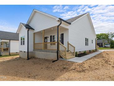Charming single-Gathering home showcasing white siding and a welcoming front porch at 1303 Whitsett St, Burlington, NC 27217