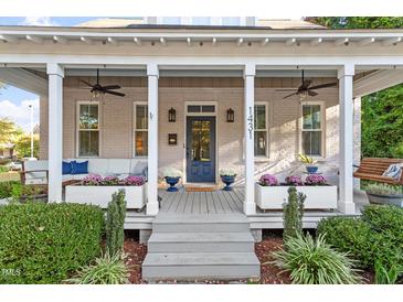 Inviting covered front porch with elegant white columns, comfortable seating, and beautiful landscaping at 1431 Courtland Dr, Raleigh, NC 27604