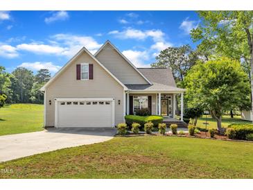 Charming single-Gathering home featuring a manicured lawn, two-car garage, and inviting front porch at 202 Reeder Branch Dr, Clayton, NC 27520