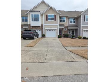 Attractive townhouse exterior showcases stone accents, and individual garages with a shared driveway at 204 Stockton Gorge Rd. Rd, Morrisville, NC 27560
