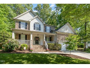 Charming home with a welcoming front porch, stone accents, and lush landscaping at 215 Hopesworth Ct, Hillsborough, NC 27278