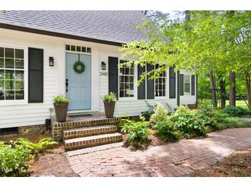Charming home featuring a light blue front door with classic black shutters and a brick walkway at 2481 Foxwood Dr, Chapel Hill, NC 27514