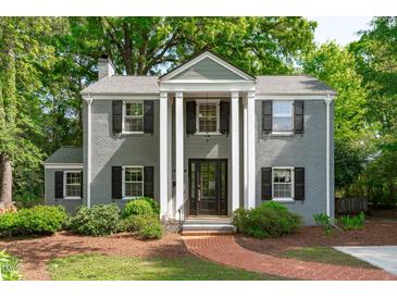 Charming two-story home with a brick walkway, black shutters, and manicured landscaping at 2704 Fairview Rd, Raleigh, NC 27608
