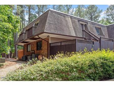 Charming townhome featuring a brick facade, cozy balcony, and lush green landscaping at 294 Summerwalk Cir, Chapel Hill, NC 27517